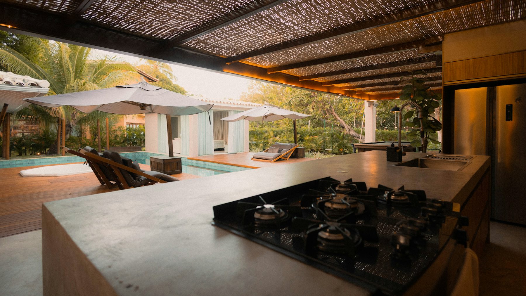 Sample outdoor kitchen and pool under a pergola